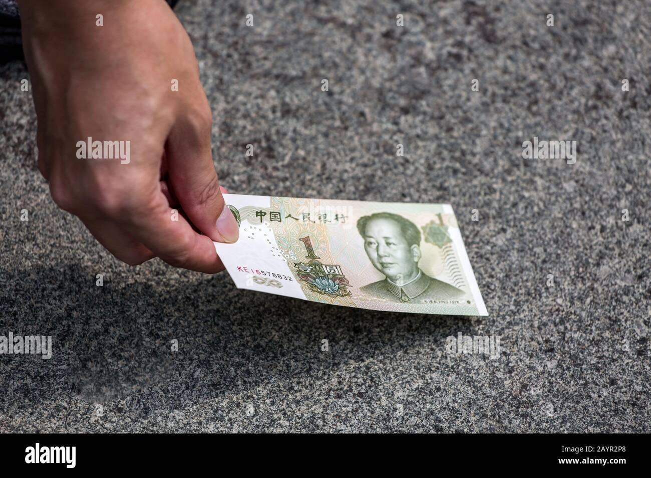 Prendendo 1 moneta cinese RMB nota sul pavimento Foto Stock