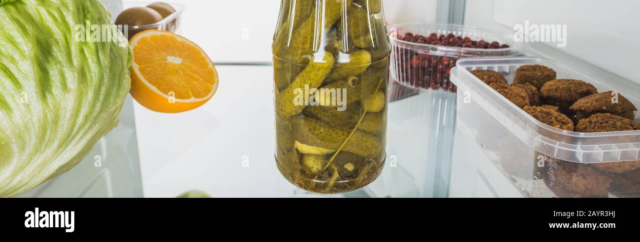 Shot panoramico di sottaceti con cotolette e frutta fresca sul ripiano frigo isolato su bianco, immagine stock Foto Stock