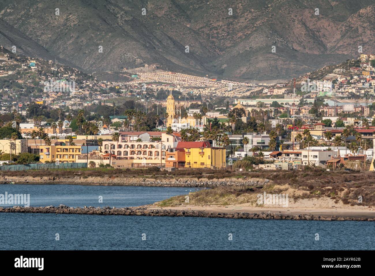 Ensenada, Messico - 17 gennaio 2012: Edifici colorati sul litorale con torri di Cattedrale di Guadalupe sul retro, circondato da paesaggio urbano Foto Stock