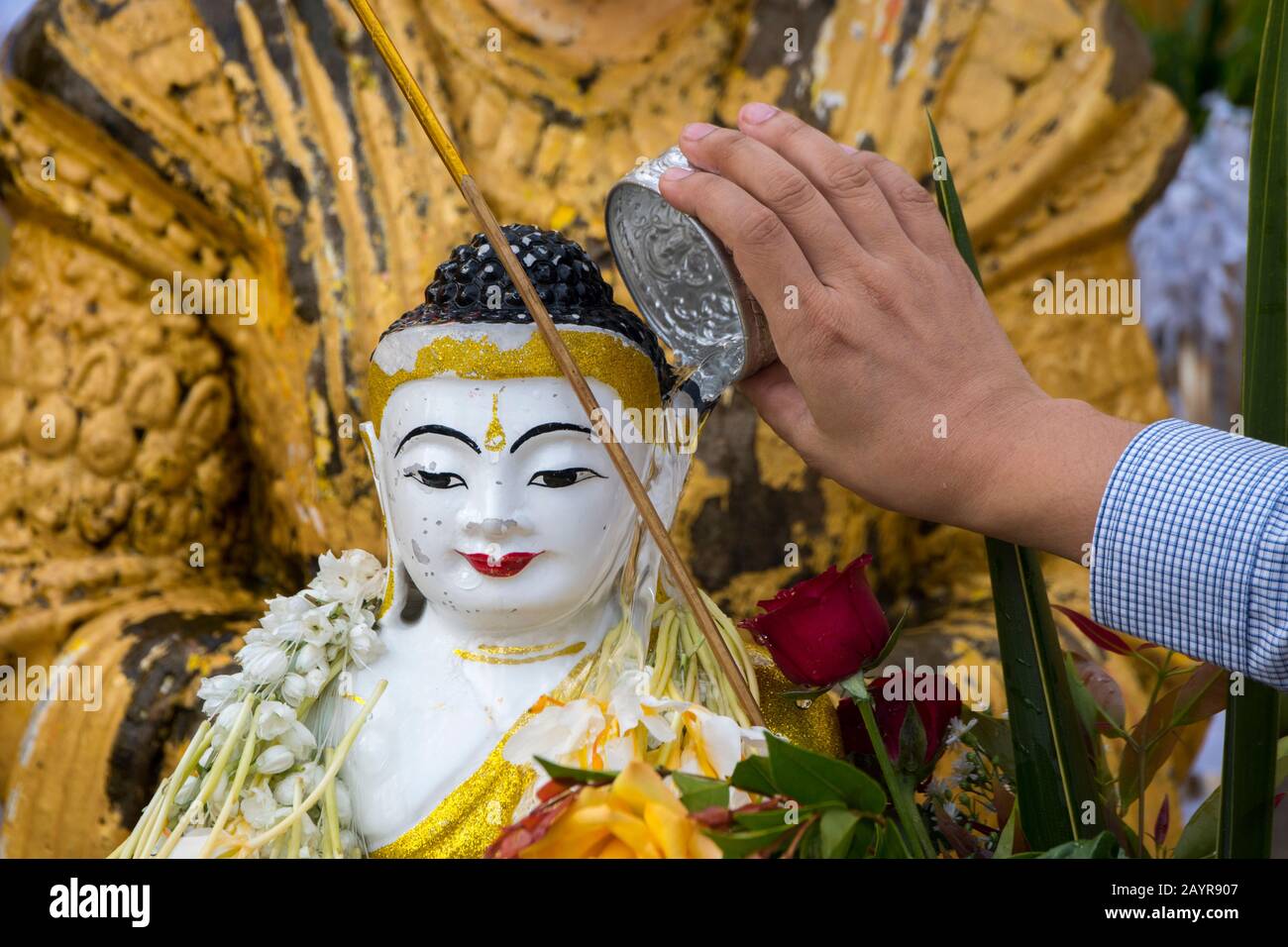 La gente che versa l'acqua su un Buddha, chiedendo la fortuna al loro posto planetario alla pagoda Shwedagon di 2.500 anni a Yangon (Rangoon), il lar Foto Stock