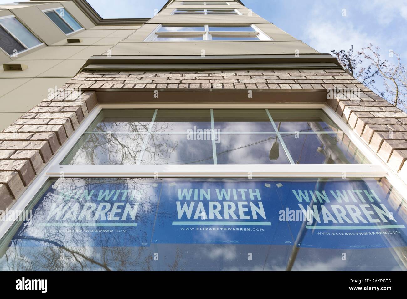 Piene di poster, le finestre dell'ufficio della campagna di Seattle di Elizabeth Warren riflettono il cielo blu e le nuvole nella regina Inferiore Anne domenica 16 febbraio 2020. Foto Stock