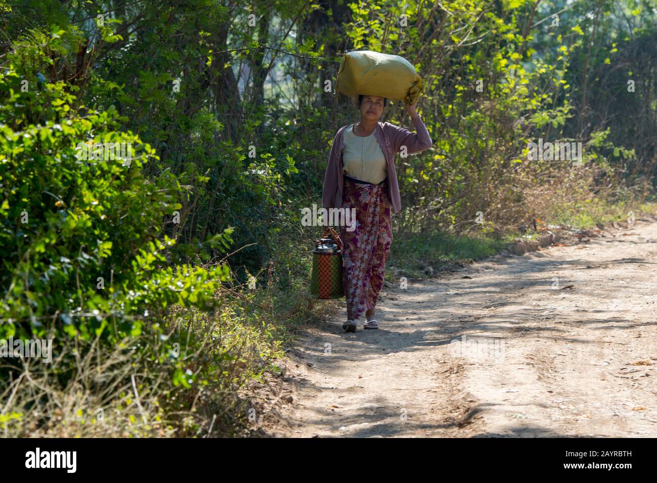 Una donna sta portando le merci al mercato nel villaggio di Khaung Tai sul lago di Inle in Myanmar. Foto Stock