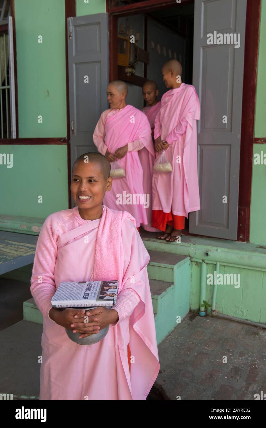 Le monache stanno uscendo dal loro dormitorio per la cerimonia di consegna degli elemosini a Zayertheingi, un nunnery buddista a Sagaing, una città fuori di Mandalay, Myanmar. Foto Stock