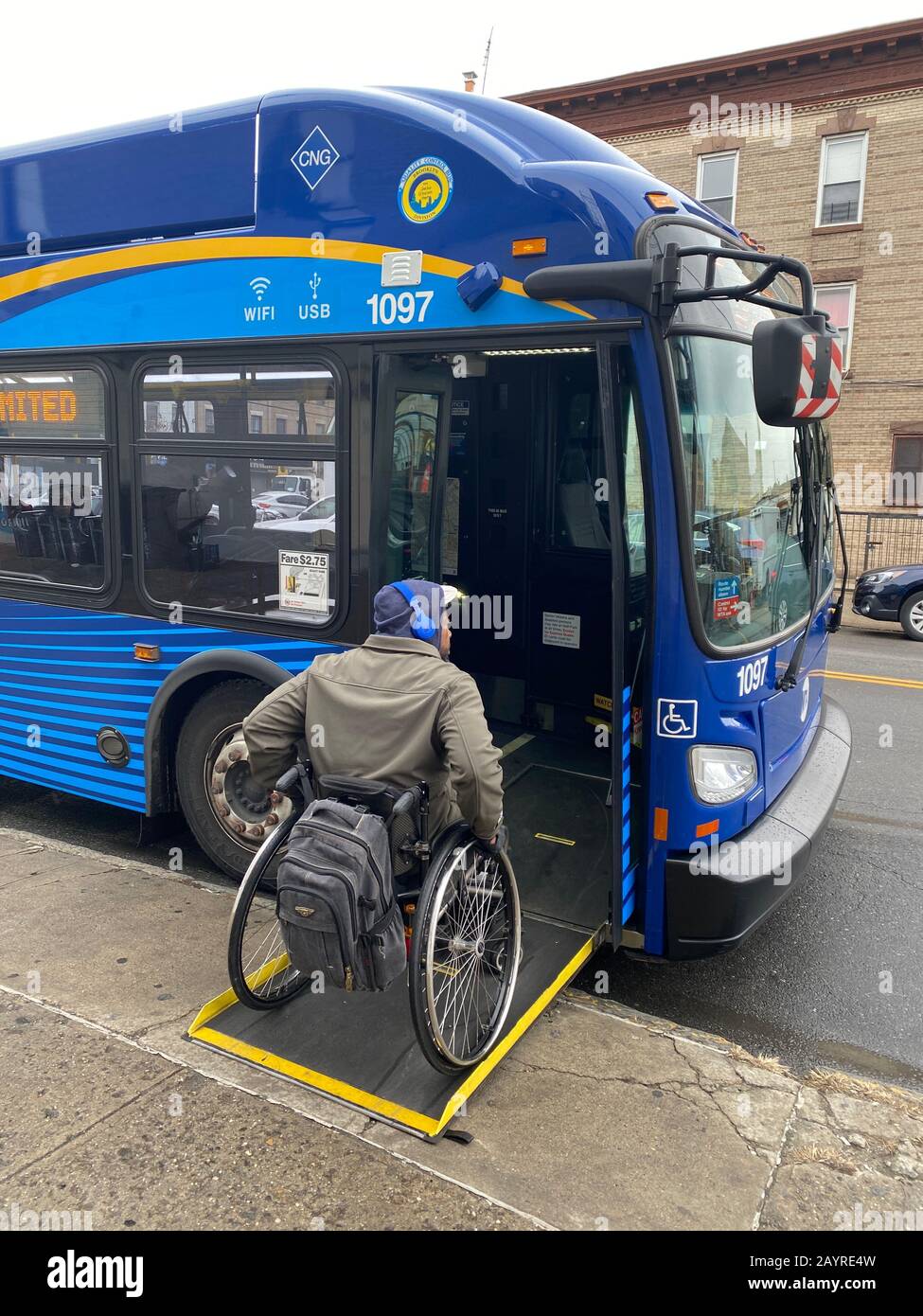 Un uomo disabile che si trova su un autobus di New York City dotato di una rampa per sedie a rotelle. Foto Stock