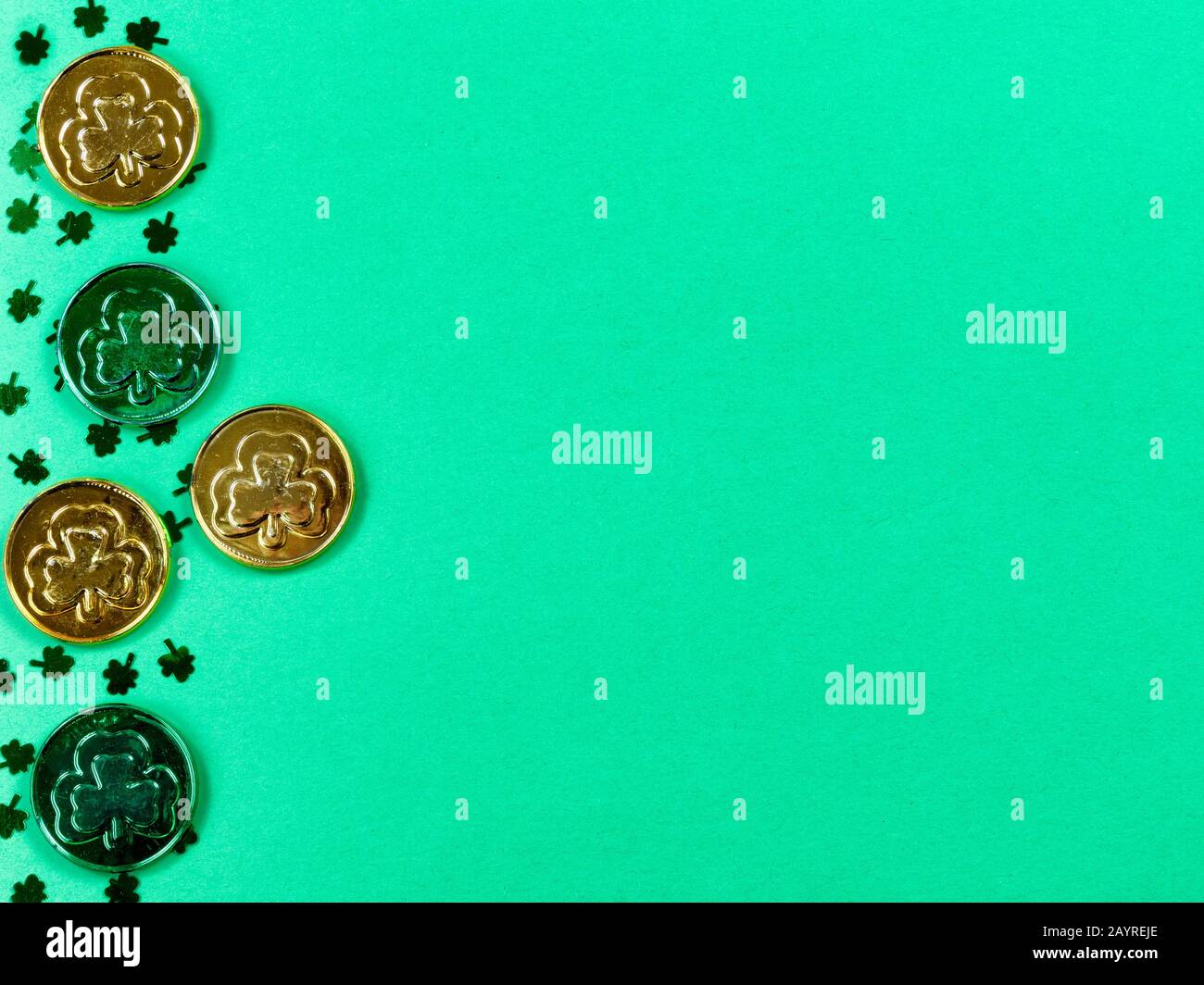 Giornata di San Patrizio con il confine di scogli e monete d'oro su sfondo verde con spazio copia Foto Stock