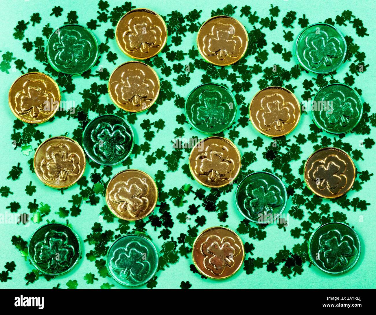 Giornata di San Patrizio con scogli e monete lucide su sfondo verde in formato pieno cornice Foto Stock