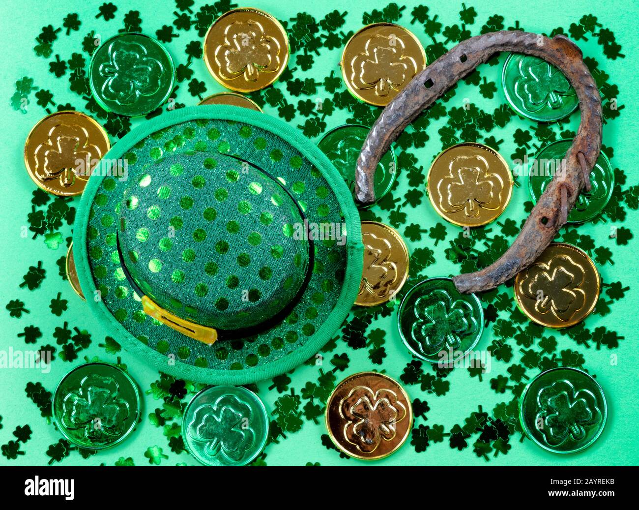 Giornata di San Patrizio con scogli, monete, cappello e ferro di cavallo su sfondo verde in formato pieno cornice Foto Stock