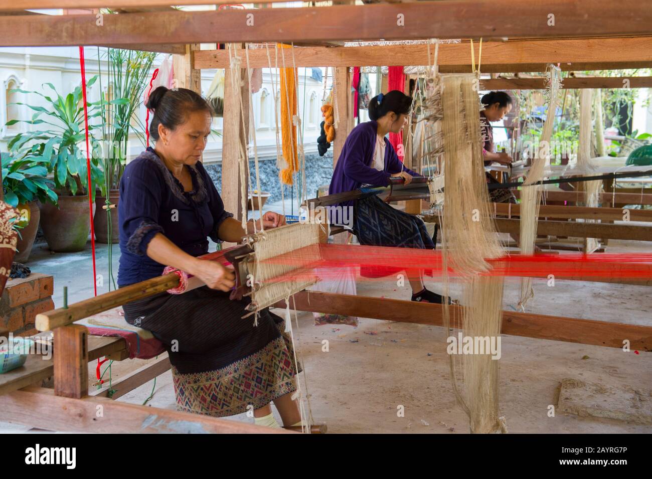 Donne su un telaio tessitura seta e tessuti di cotone ad un laboratorio in Ban Xang Khong, un villaggio vicino Luang Prabang nel Laos centrale, che è conosciuto per loro Foto Stock