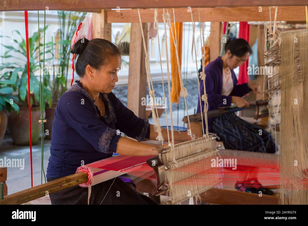 Donne su un telaio tessitura seta e tessuti di cotone ad un laboratorio in Ban Xang Khong, un villaggio vicino Luang Prabang nel Laos centrale, che è conosciuto per loro Foto Stock