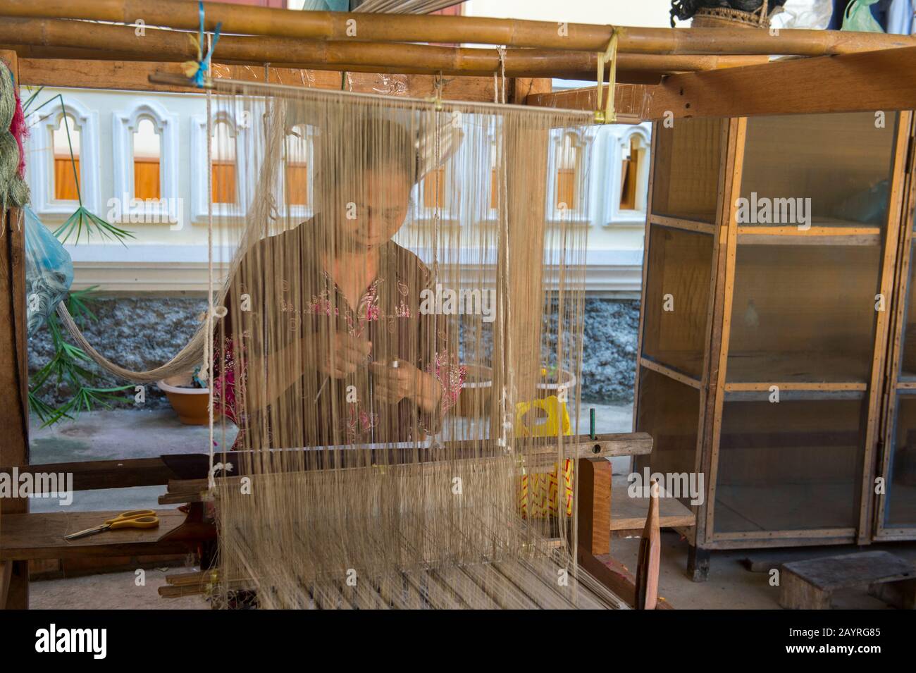 Una donna su un telaio sta tessendo tessuti di seta e cotone ad un laboratorio in Ban Xang Khong, un villaggio vicino Luang Prabang nel Laos centrale, che è conosciuto per Foto Stock