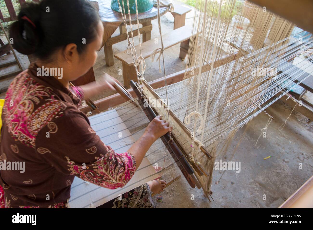 Una donna su un telaio sta tessendo tessuti di seta e cotone ad un laboratorio in Ban Xang Khong, un villaggio vicino Luang Prabang nel Laos centrale, che è conosciuto per Foto Stock