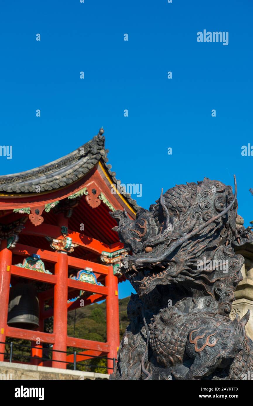 Primo piano di una statua di drago di bronzo con il campanile del tempio Kiyomizu-deraTemple (sito patrimonio dell'umanità dell'UNESCO) a Kyoto, Giappone, sullo sfondo, che w Foto Stock