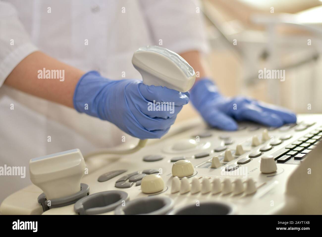 Trasduttore a ultrasuoni con gel in una mano medica su uno sfondo del pannello. Foto Stock