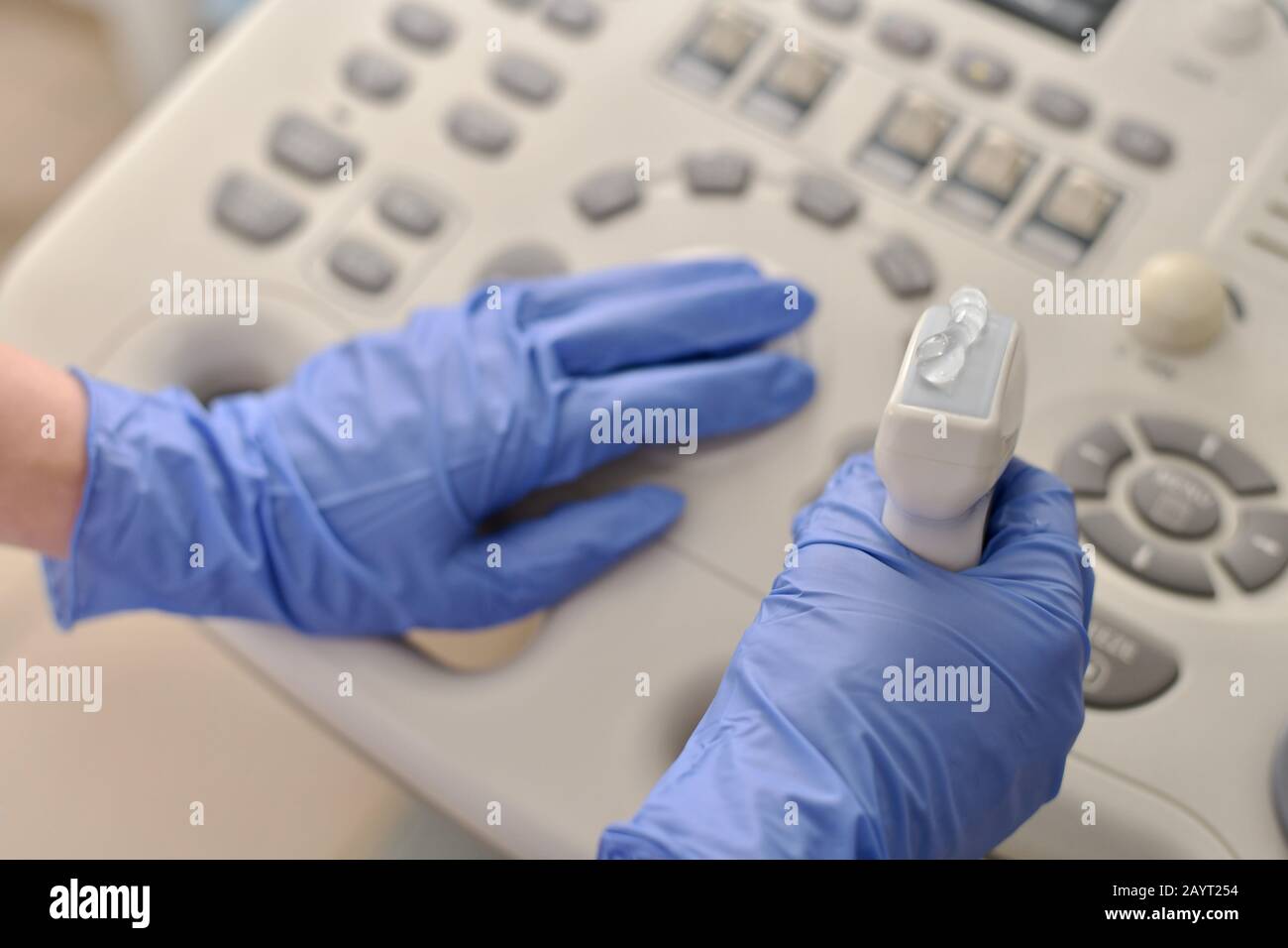 Trasduttore a ultrasuoni con gel in mano, guardando il lato medico sul pannello. Foto Stock