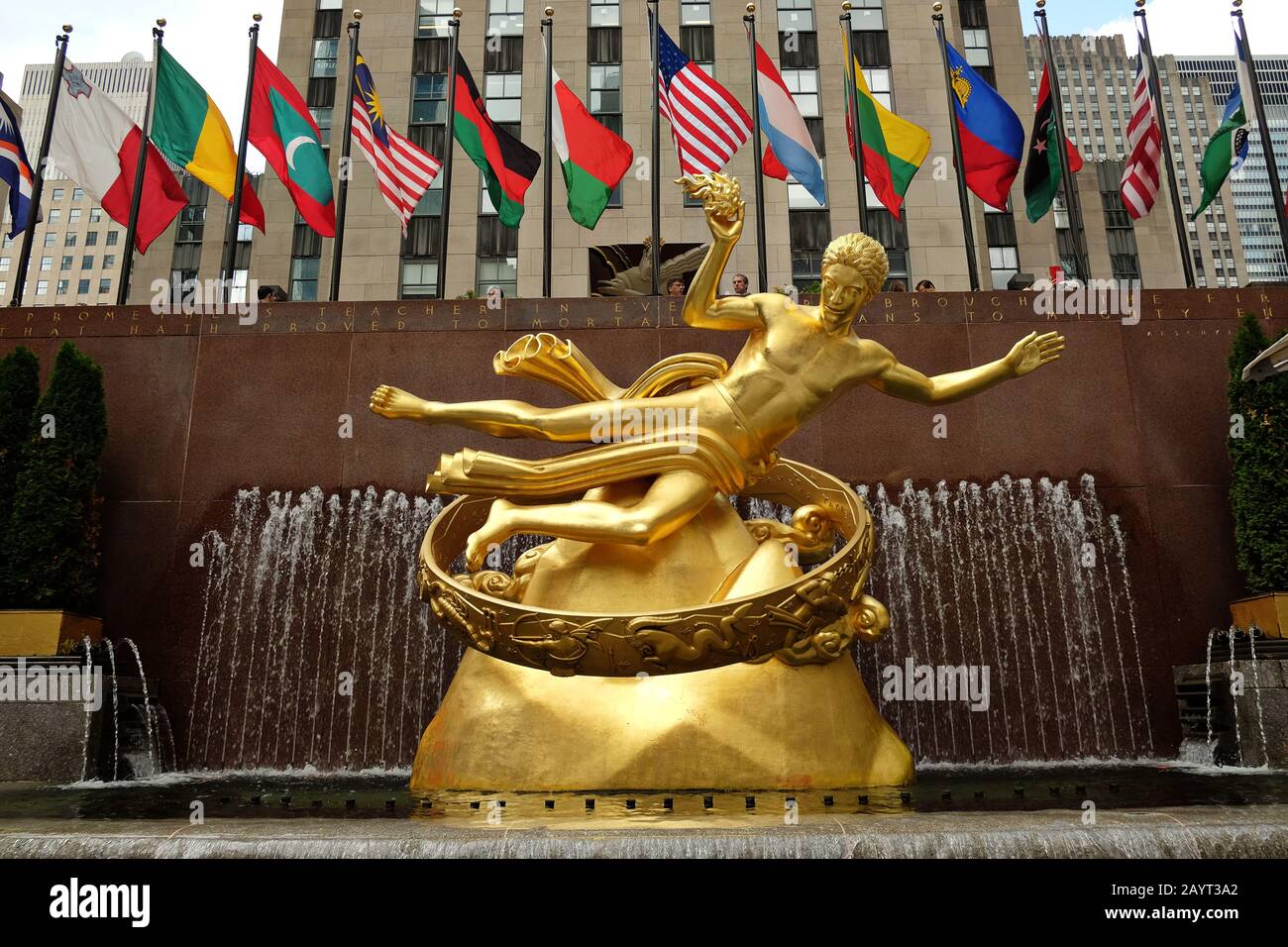Bella Art Deco Gold Prometheus Statua, e colorato World Flags Flying, Lower plaza del Rockefeller Center a Manhattan, New York City Foto Stock