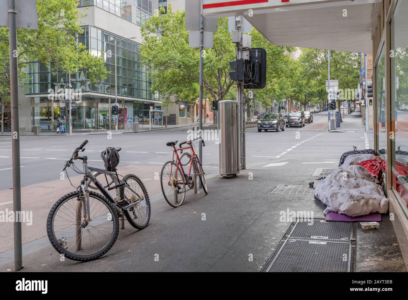 Un senzatetto che dorme per strada all'angolo tra Exhibition e Lonsdale Street a Melbourne, in Australia, presto il sabato mattina Foto Stock