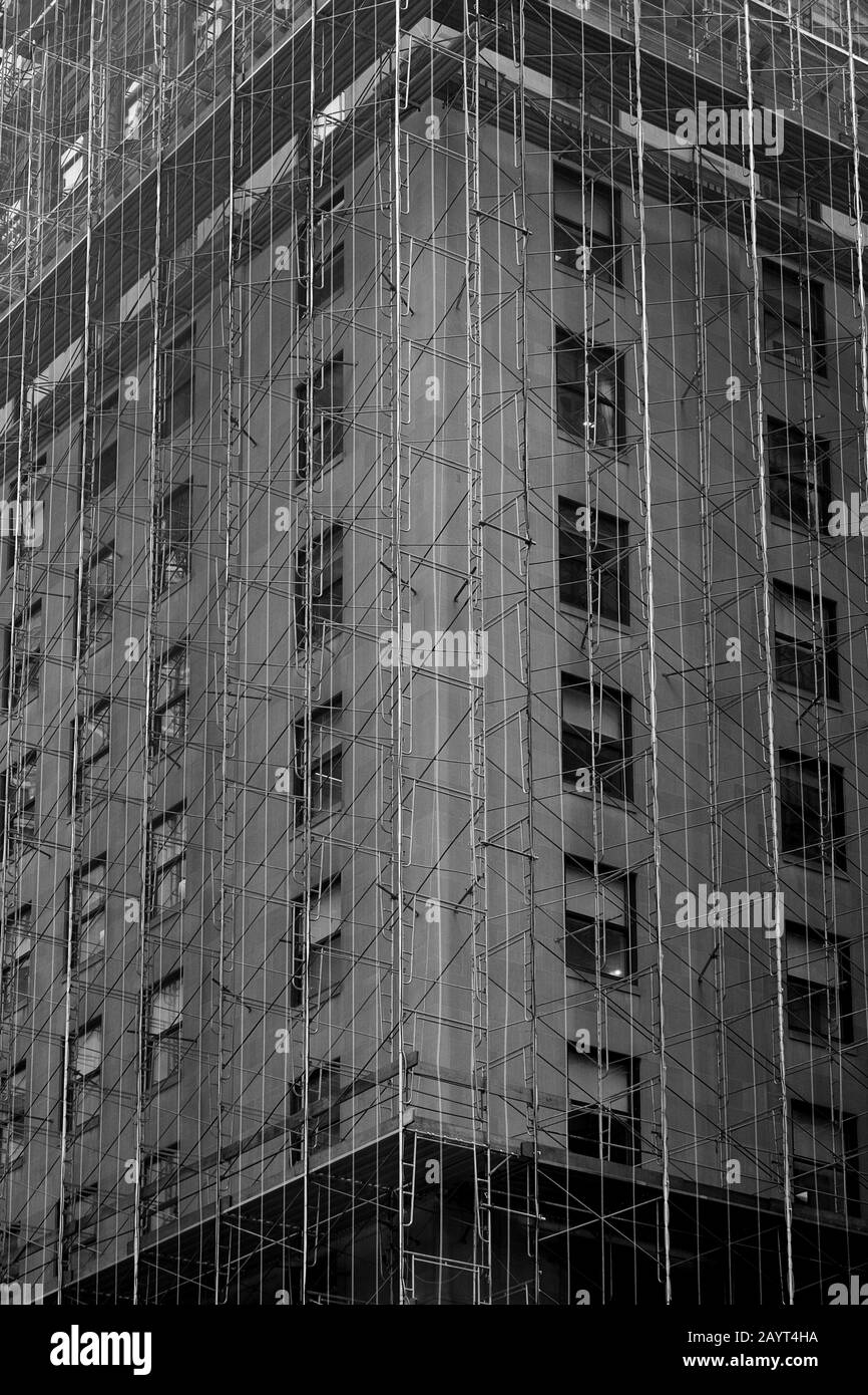 Un pettegolatore come la guaina di tessuto e impalcature copre l'esterno di un grattacielo di New York in fase di ristrutturazione Foto Stock