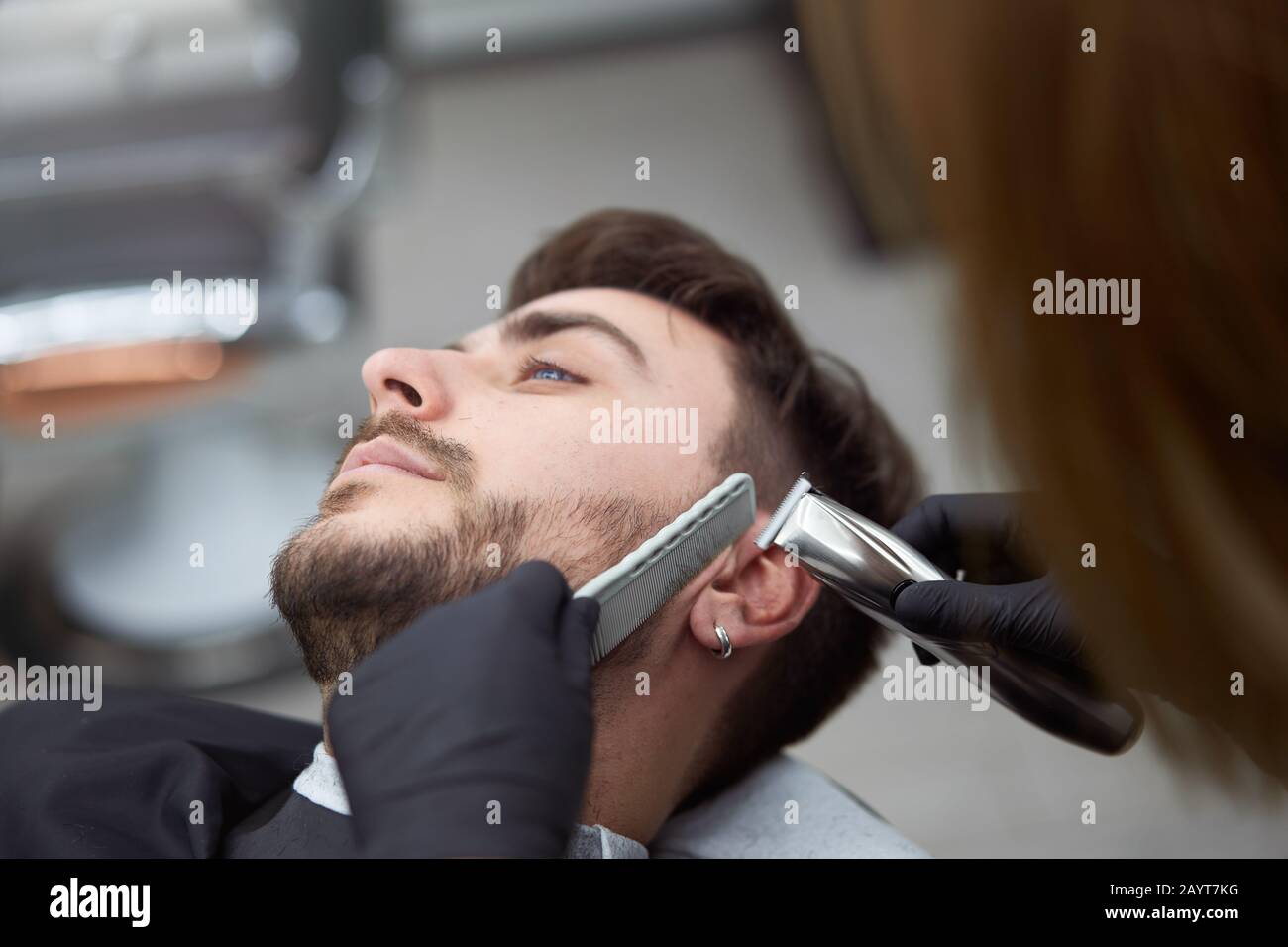 Giovane adulto bella donna caucasica parrucchiere taglia barba bel uomo al  barbiere moderno Felice gay seduta sedia uomini salone di bellezza. Cura  della barba. M Foto stock - Alamy