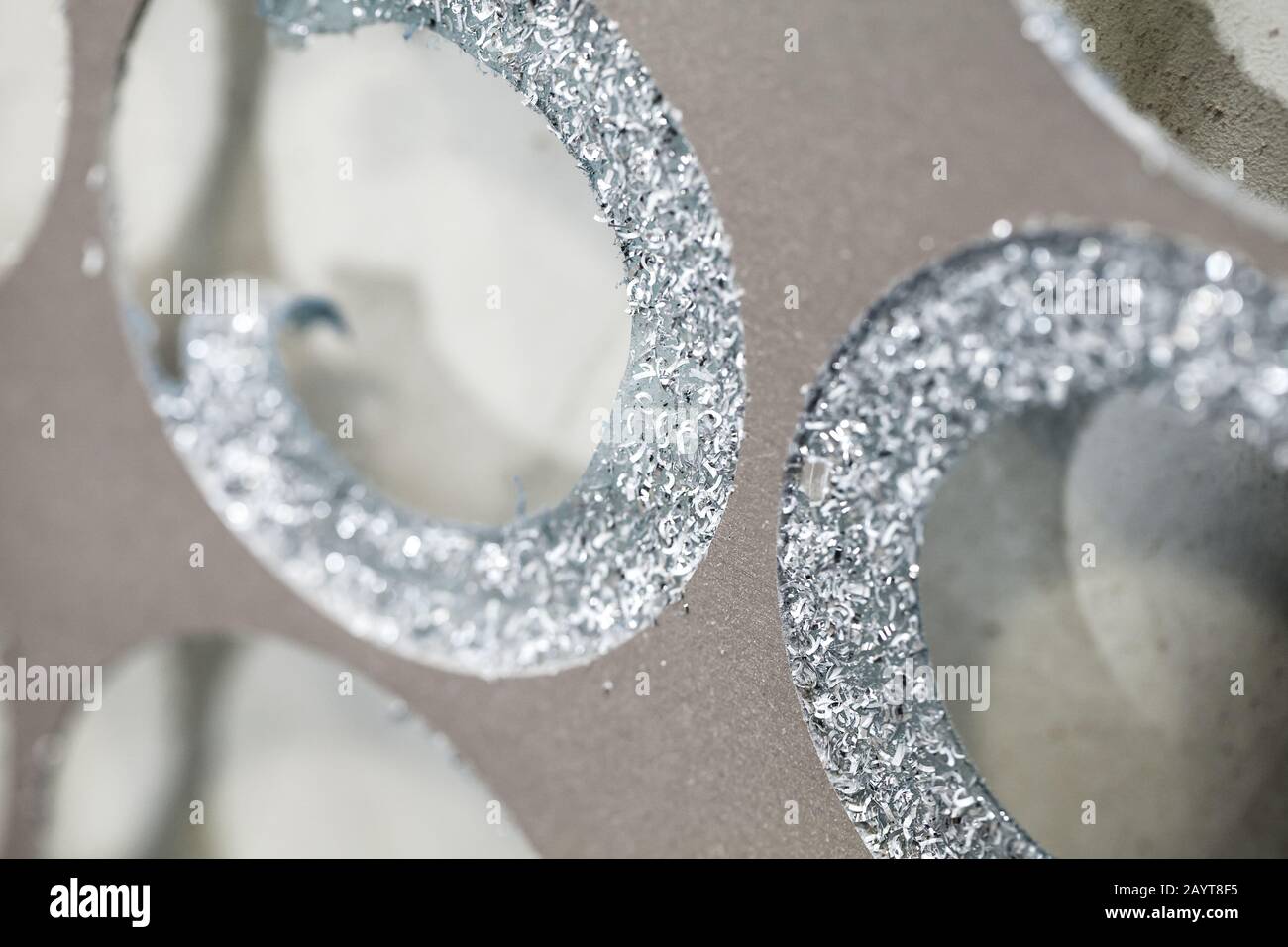 Scarti di lamiera di alluminio con fori e segatura, foto di primo piano dei rifiuti di produzione Foto Stock