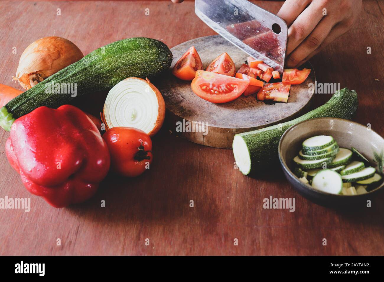 Tritare verdure fresche su tavola di legno che mostra il concetto di stile di vita vegano, dieta sana e vita pulita Foto Stock