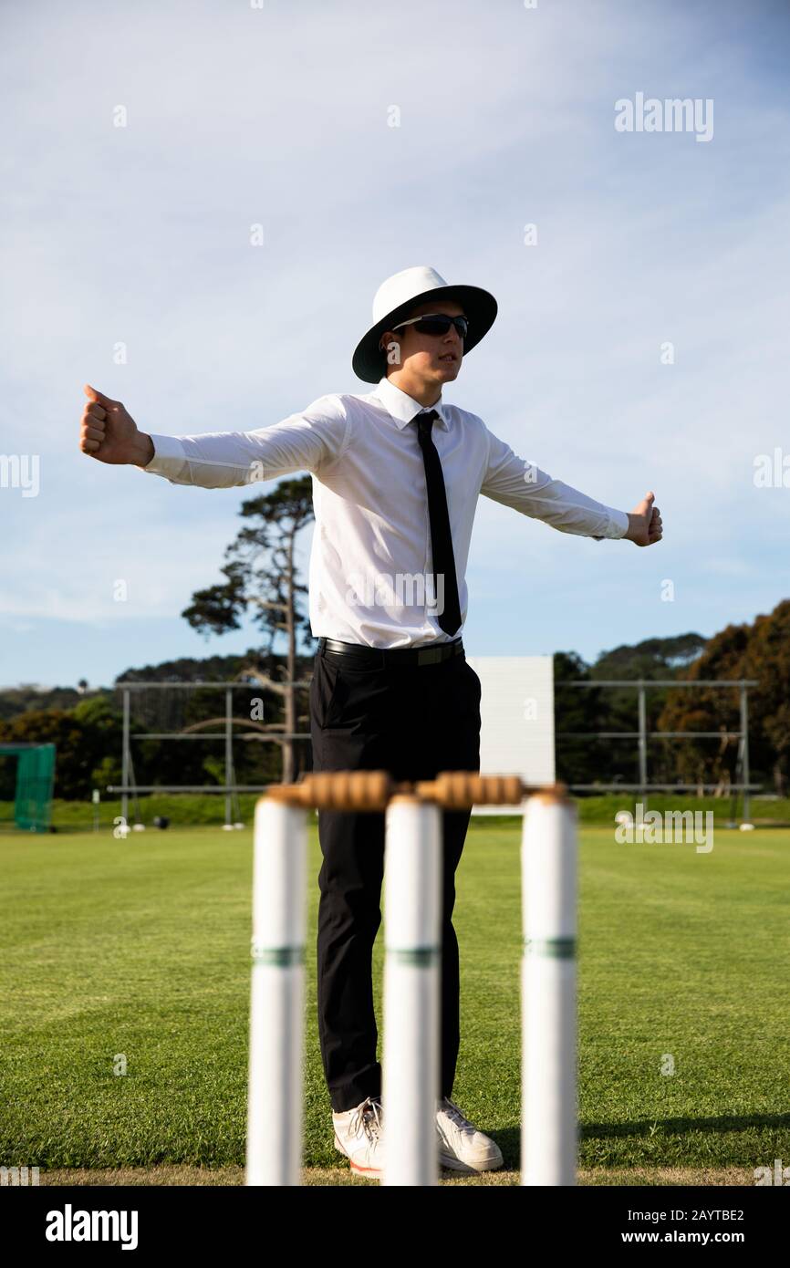 Cricket umpire facendo segni in piedi su un campo di cricket Foto Stock