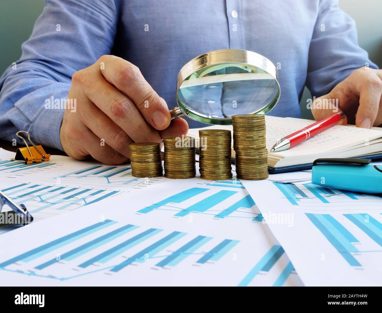 Auditor effettua audit e controlli finanziari con un profitto di lente d'ingrandimento. Foto Stock