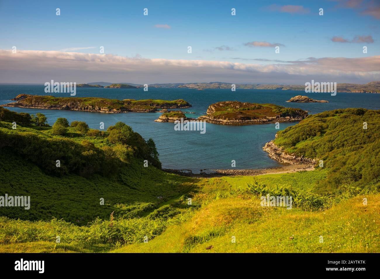 La vista delle isole e di una spiaggia rocciosa dalla cima di una collina chiamata Drumbeg Viewpoint, è immersa nella luce del giorno duing una giornata estiva, lungo la costa settentrionale 500 Foto Stock