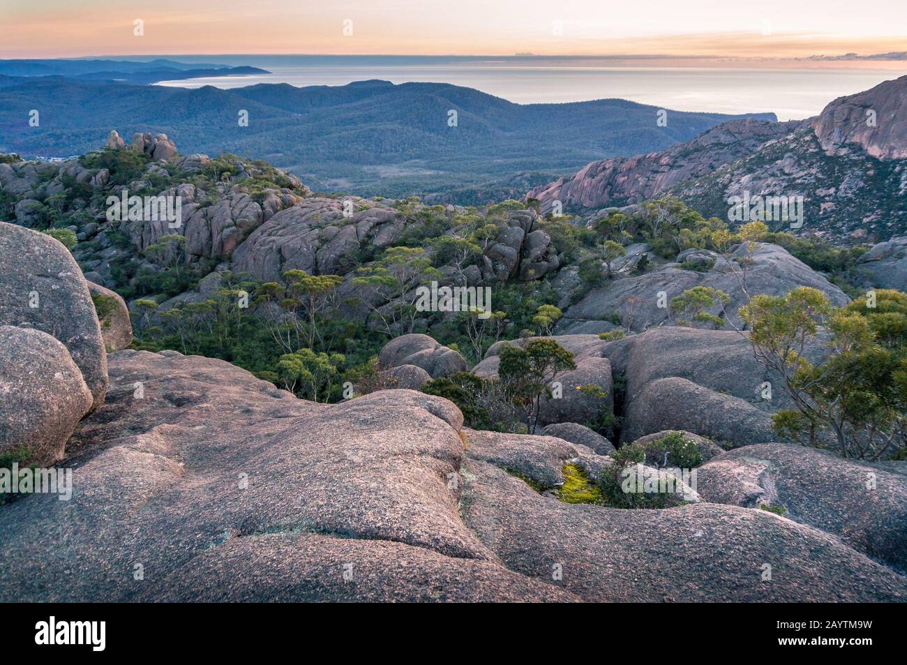 Guardando giù i massi di lava e la valle di montagna dalla montagna. Terreno montano con rocce sfondo natura. Monte Amos Al Parco Nazionale Di Freycinet Foto Stock