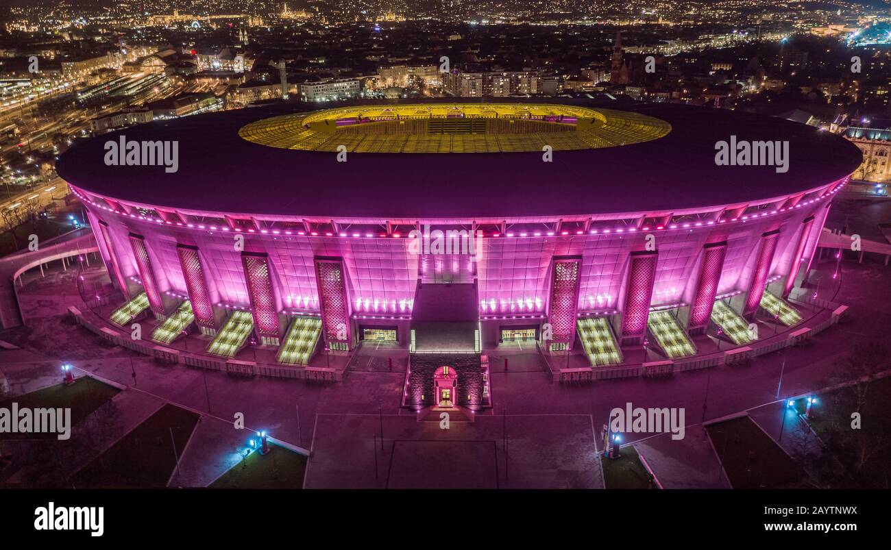 Budapest, Ungheria - veduta aerea del nuovissimo stadio Ferenc Puskas di Budapest, aka Puskas Arena, con rosa e viola unici illuminati di notte Foto Stock