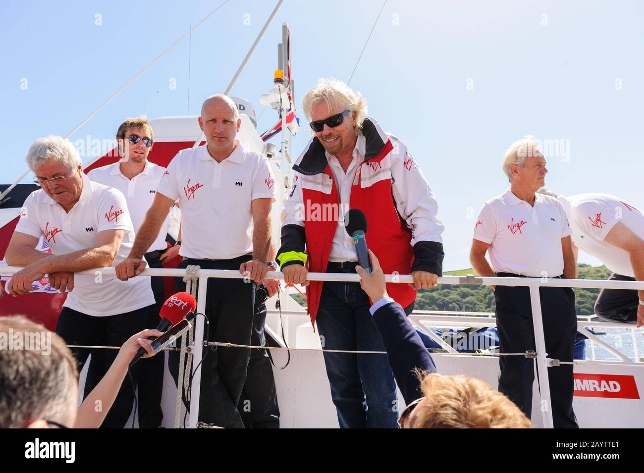 Sir Richard Branson, con l'equipaggio originale e nuovo della Virgin Atlantic Challenger II che arriva nel porto di Fowey per celebrare la loro riunione. Foto Stock