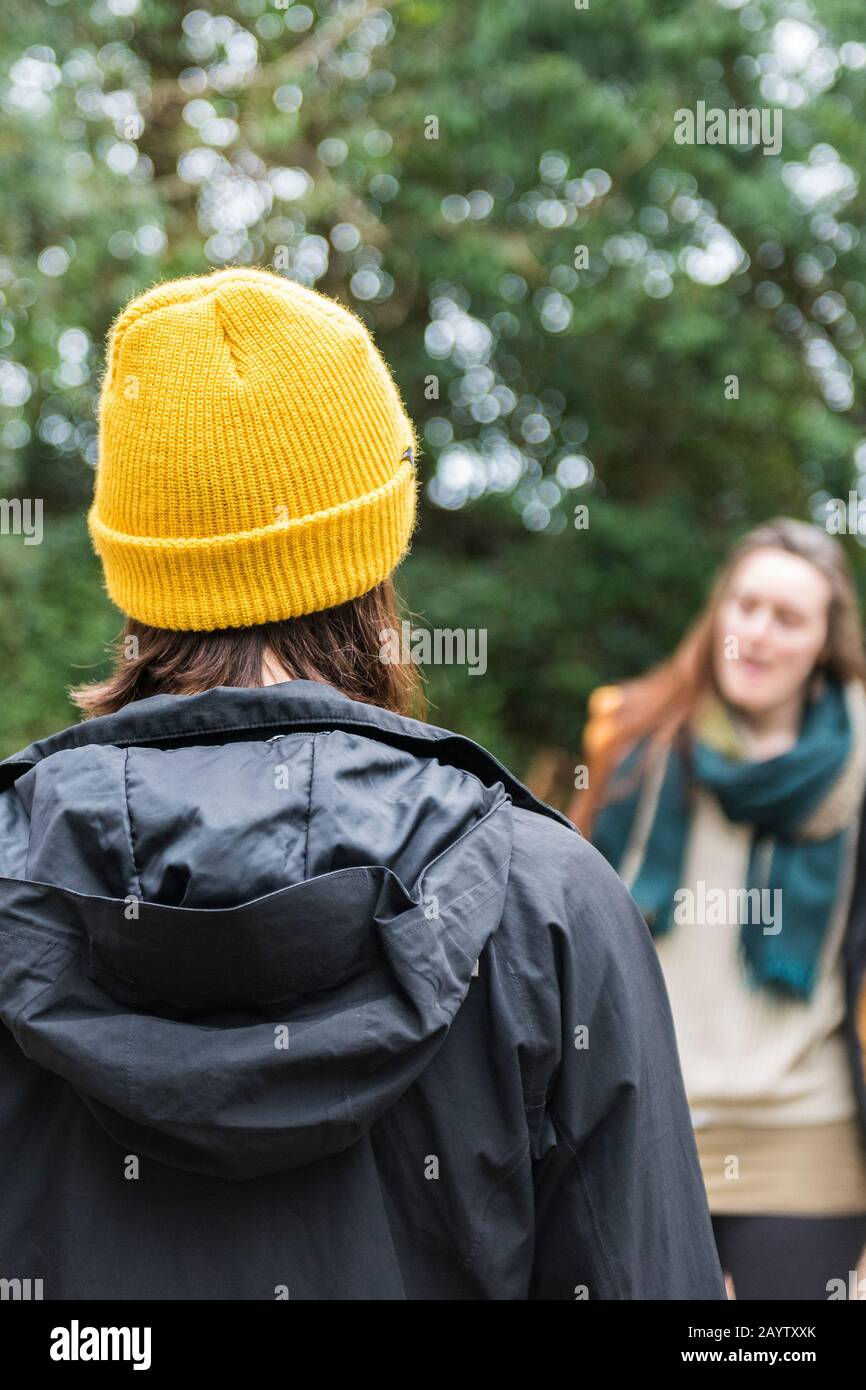 Una vista posteriore di una donna che indossa un cappello giallo brillante lavorato a maglia in tempo freddo. Foto Stock