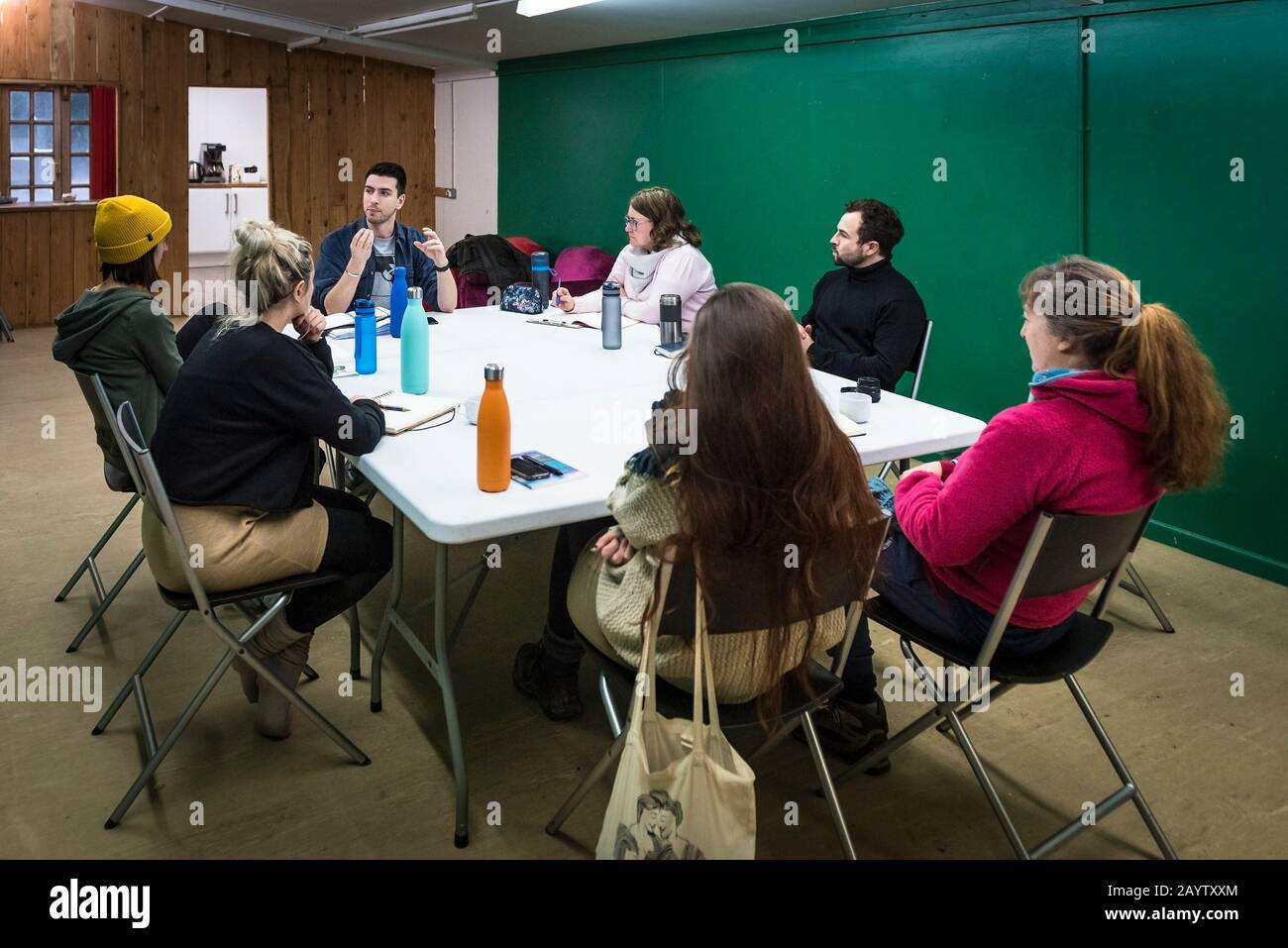 Attori in una sala prove ascoltando un regista che parla della ricerca e dello sviluppo di nuove opere teatrali. Foto Stock