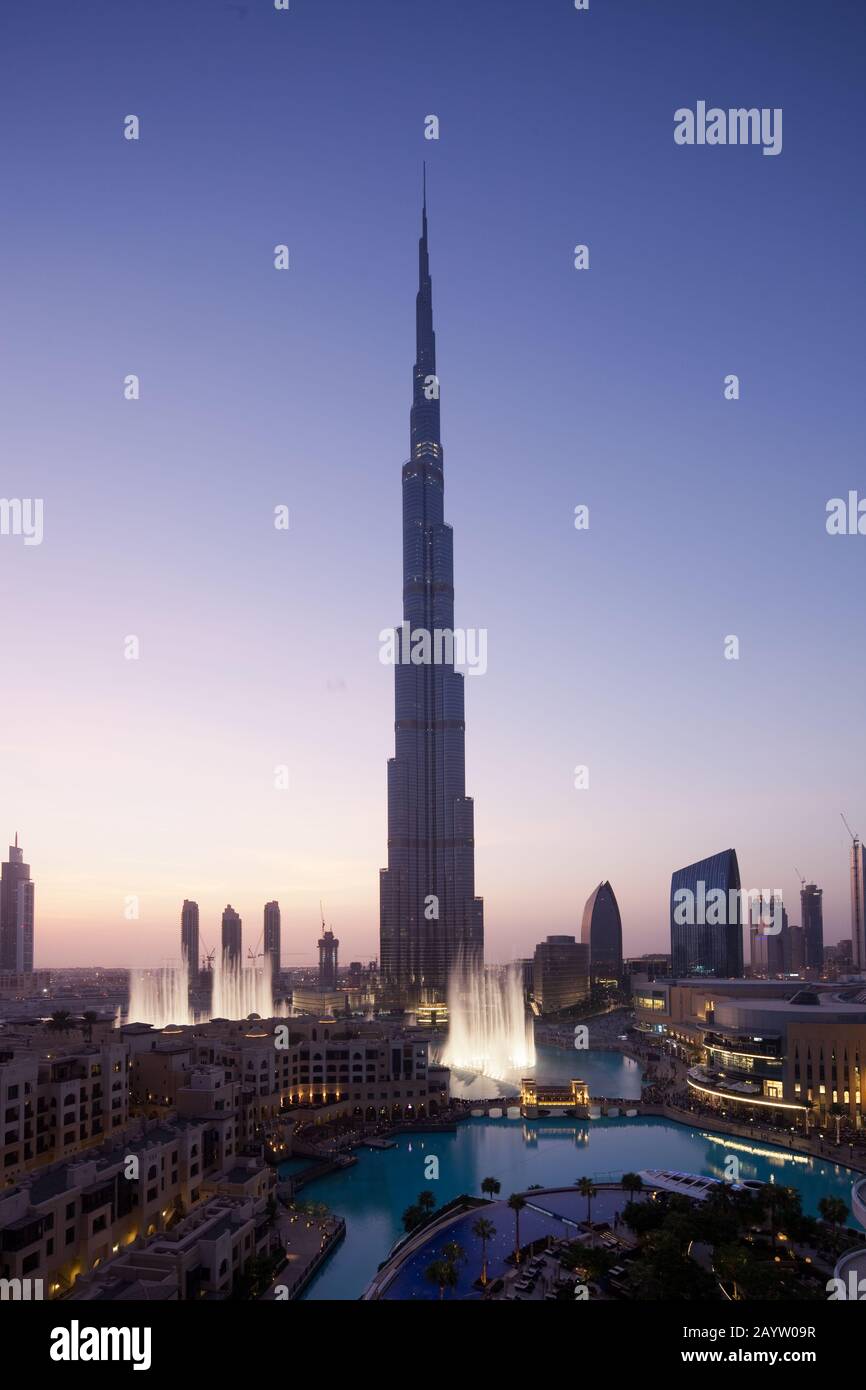 La fontana di Dubai intrattiene i visitatori al tramonto di fronte al Burj Khalifa a Dubai, Emirati Arabi Uniti. Foto Stock