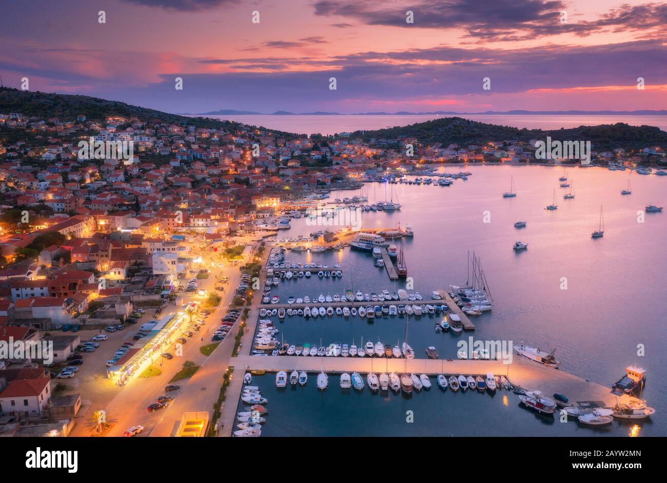 Vista aerea di barche e yacht in porto e città di notte. Foto Stock