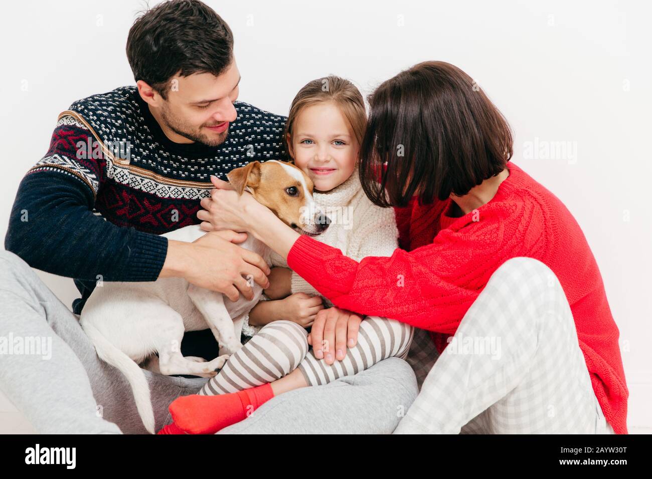 Tre membri della famiglia hanno comprato pedigree jack russell terrier cane, felici espressioni, isolati su sfondo bianco. Felice famiglia deliziosa godere insieme Foto Stock