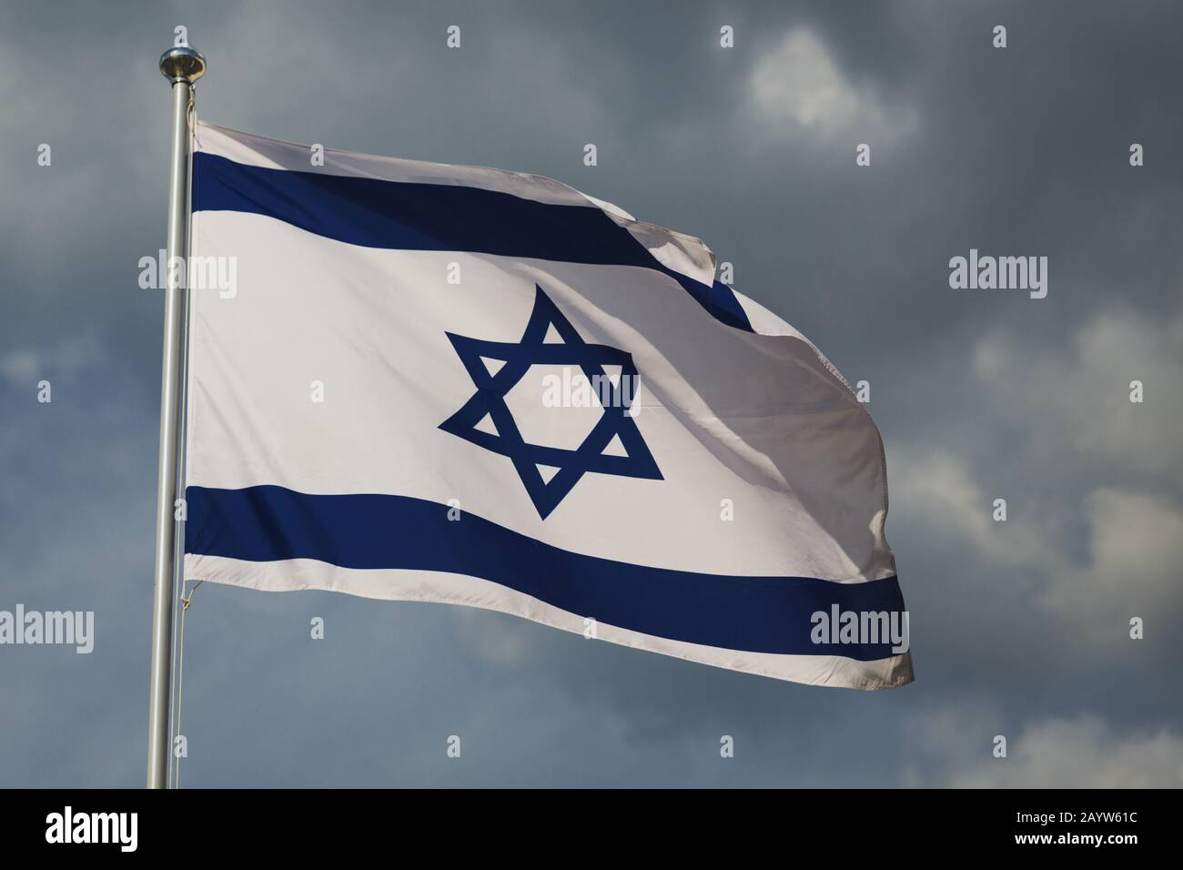 Ondeggiante bandiera colorata d'Israele contro il cielo nuvoloso. Struttura in tessuto estremamente dettagliata. Stella blu e bianca contro le nuvole. Gerusalemme capitale d'Israele. I Foto Stock