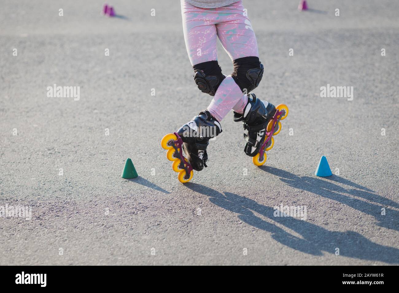 L'immagine ritagliata dell'adolescente indossa pattini a rotelle all'aperto, rollerblade attraverso le patatine, ha vacanze attive. Nessuna faccia. Hobby, esercizi e concetto di sport Foto Stock