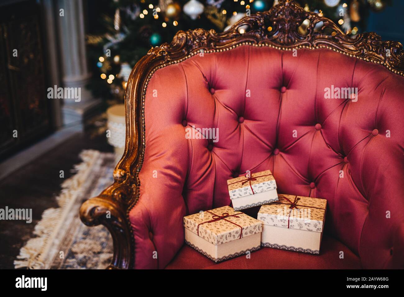 Immagine orizzontale di avvolto tre confezioni regalo su splendidi royal poltrona in ambienti chiusi. Home interni. Celebrazione, vacanze presente concetto. Natale p Foto Stock