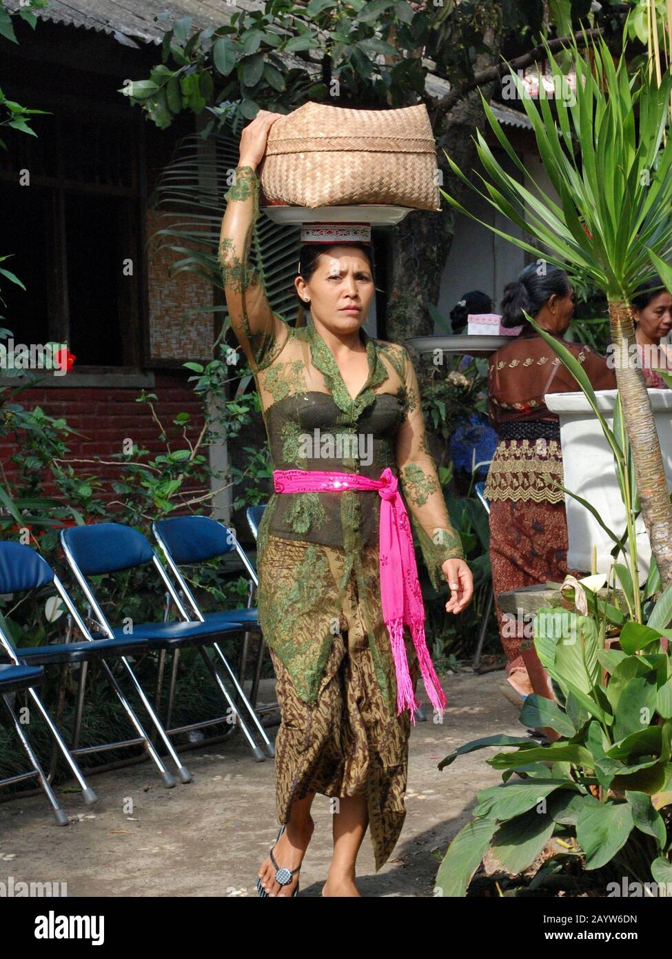 La donna Balinese porta offerte tradizionali agli dei Indù. Foto Stock