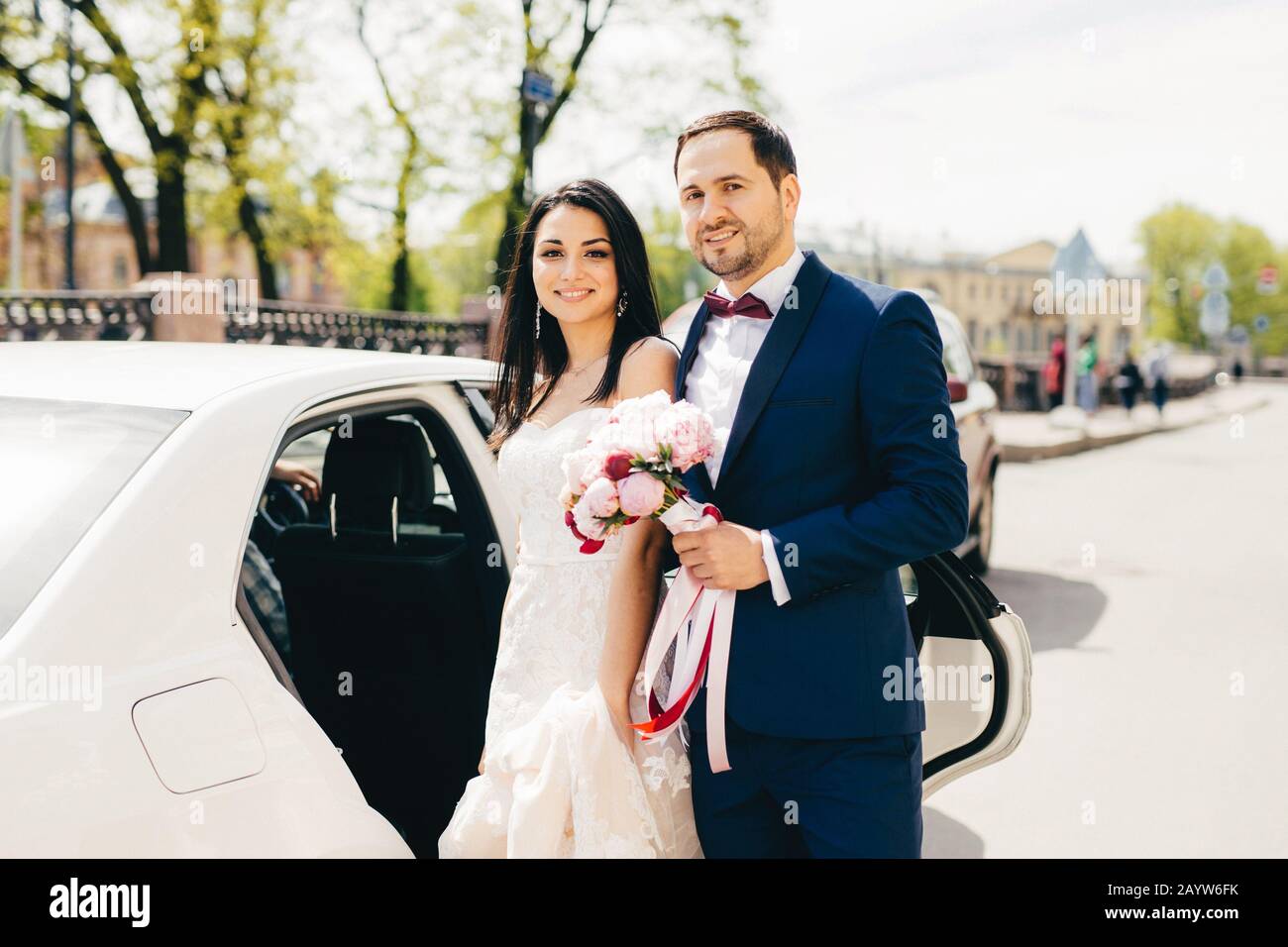 Bella coppia sposata stare accanto a un altro vicino auto, andare in ristorante per celebrare il loro matrimonio, hanno festa, invitare amici e parenti. Nuovo Foto Stock