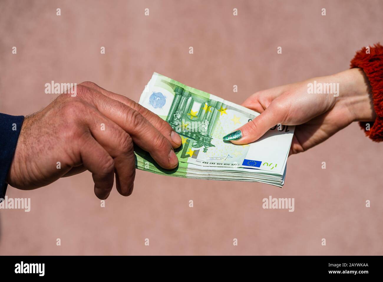 Mano che dà soldi come tangenti o punte o stipendio isolato, mano lavorato duro che prende le banconote in euro. Trasferimento di valuta e ricompensa per il duro lavoro. Foto Stock
