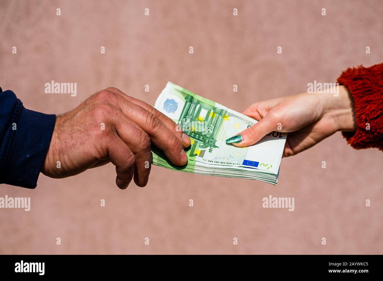 Mano che dà soldi come tangenti o punte o stipendio isolato, mano lavorato duro che prende le banconote in euro. Trasferimento di valuta e ricompensa per il duro lavoro. Foto Stock