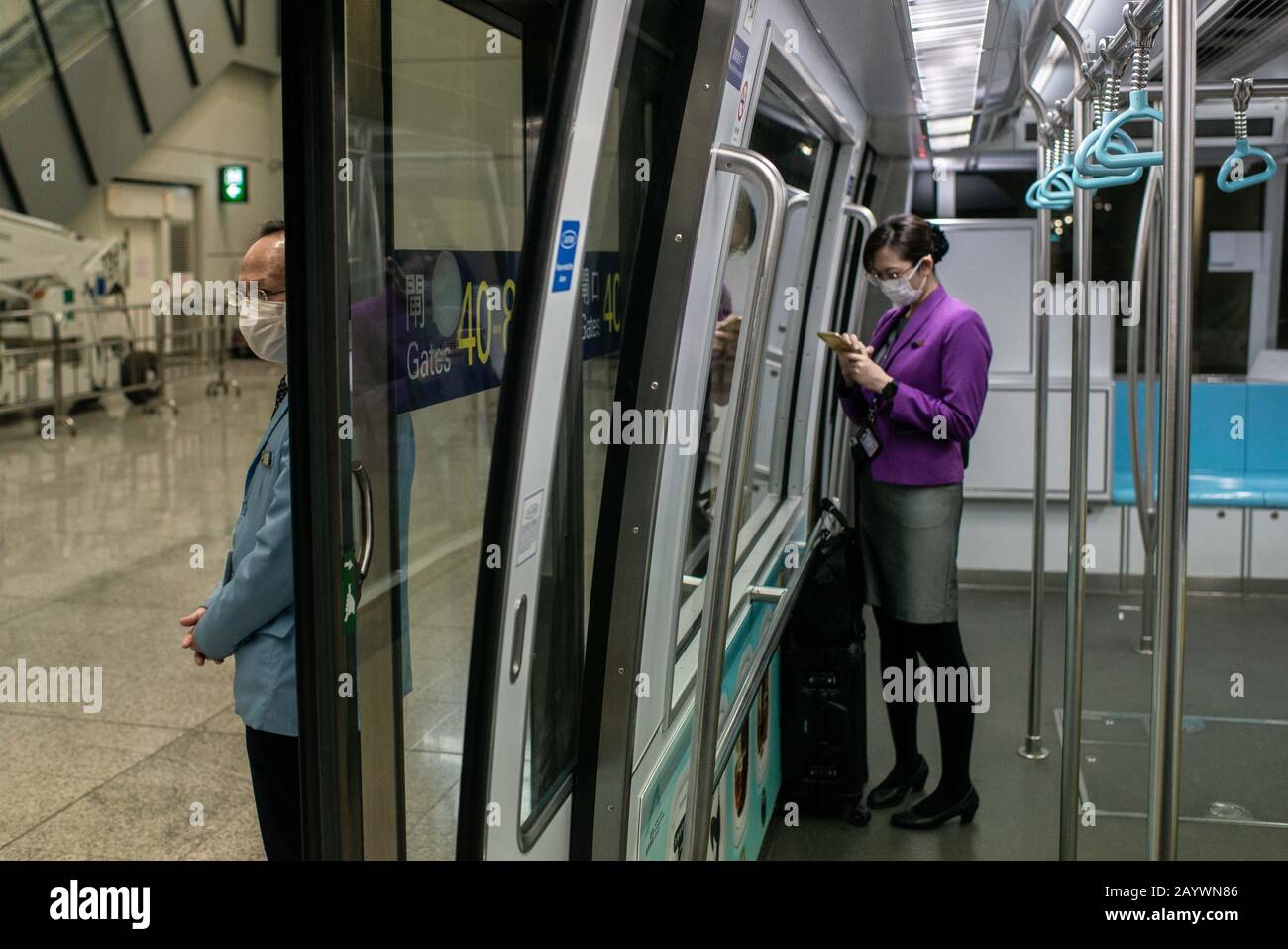 Hong Kong, Cina. 14th Feb, 2020. Un membro del personale della compagnia aerea indossa una maschera chirurgica presso una sala del terminal di partenza del treno presso l'aeroporto internazionale di Hong Kong. Con l'aumento del numero di vittime del nuovo Coronavirus, più paesi annullano i voli all'interno e all'esterno della regione. Credit: Sopa Images Limited/Alamy Live News Foto Stock
