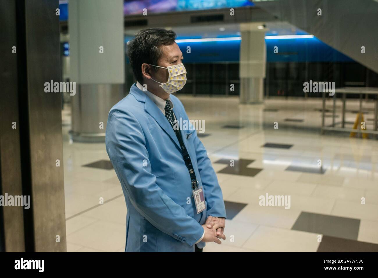 Hong Kong, Cina. 14th Feb, 2020. Un membro del personale dell'aeroporto indossa una maschera chirurgica presso una piattaforma ferroviaria presso la sala del terminal di partenza all'aeroporto internazionale di Hong Kong. Con l'aumento del numero di vittime del nuovo Coronavirus, più paesi annullano i voli all'interno e all'esterno della regione. Credit: Sopa Images Limited/Alamy Live News Foto Stock