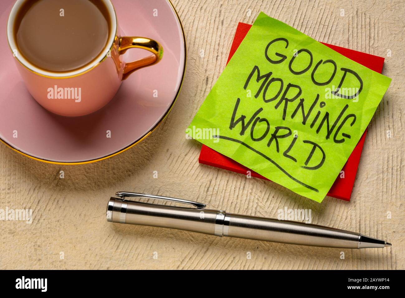 Buon Giorno mondo allegro e positivo memo - grafia su un foglietto adesivo con una tazza di caffè Foto Stock