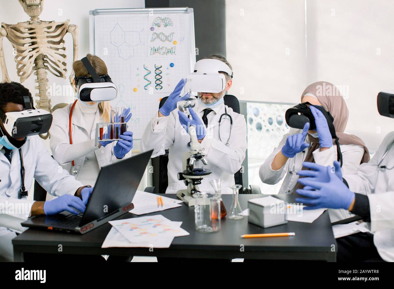 Scienziati medici in cappotti. Guanti e indossare occhiali realtà virtuale lavorando in laboratorio, facendo la ricerca medica. Biotecnologia, chimica, scienza Foto Stock
