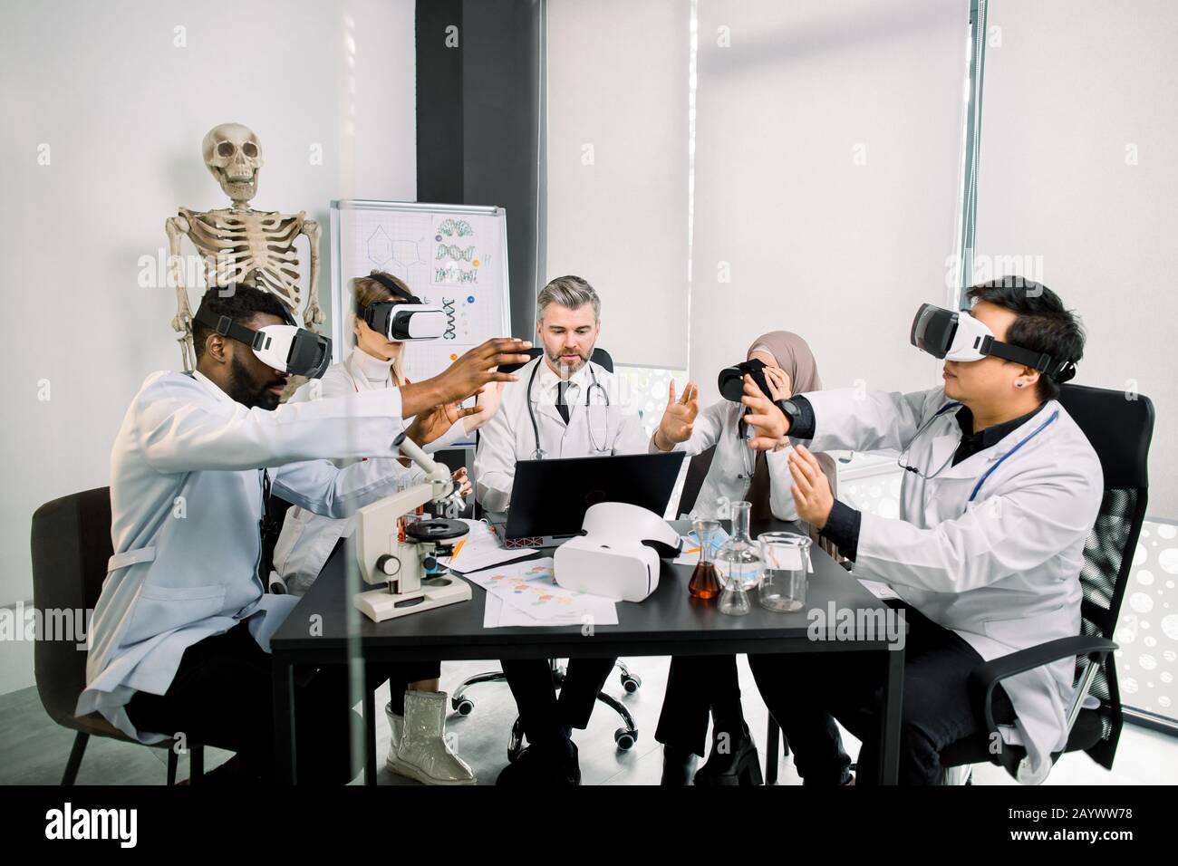Biotecnologia, chimica, scienza, sanità, concetto di realtà virtuale. Specialisti di diagnostica medica, scienziati, medici che indossano occhiali di protezione per la realtà virtuale che analizzano nuovi Foto Stock