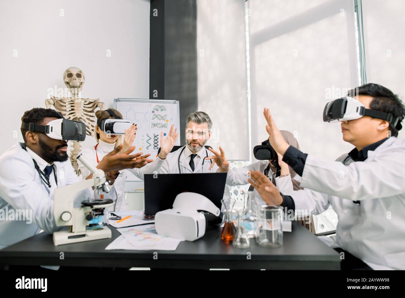 Biotecnologia, chimica, scienza, sanità, concetto di realtà virtuale. Specialisti di diagnostica medica, scienziati, medici che indossano occhiali di protezione per la realtà virtuale che analizzano nuovi Foto Stock