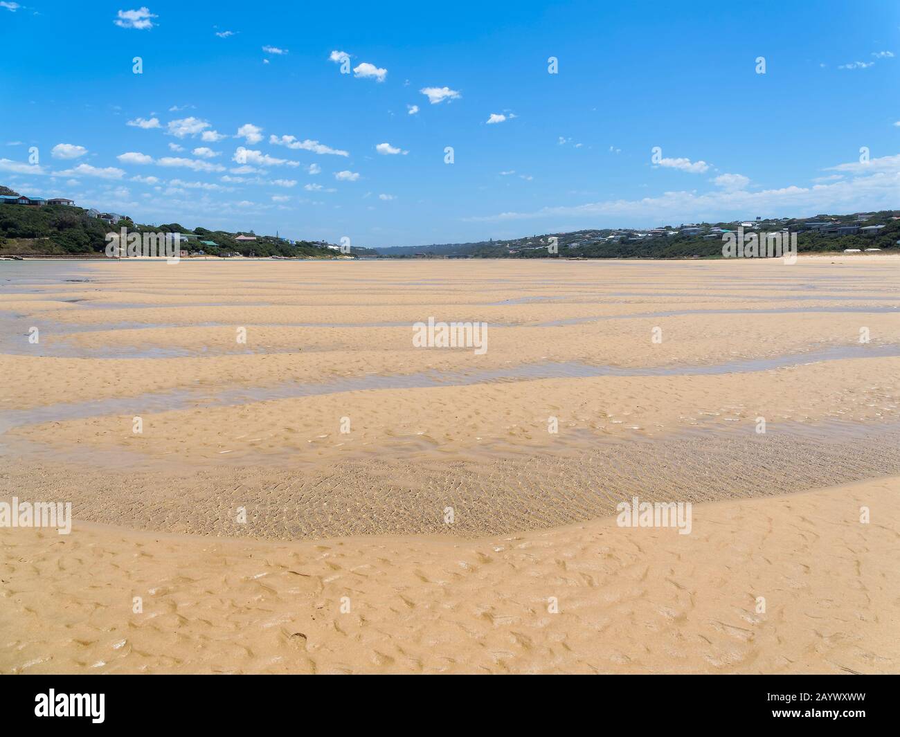 Lungo il fiume Bushmans con la bassa marea, su sabbia bagnata e le ondulate piscine di marea Foto Stock