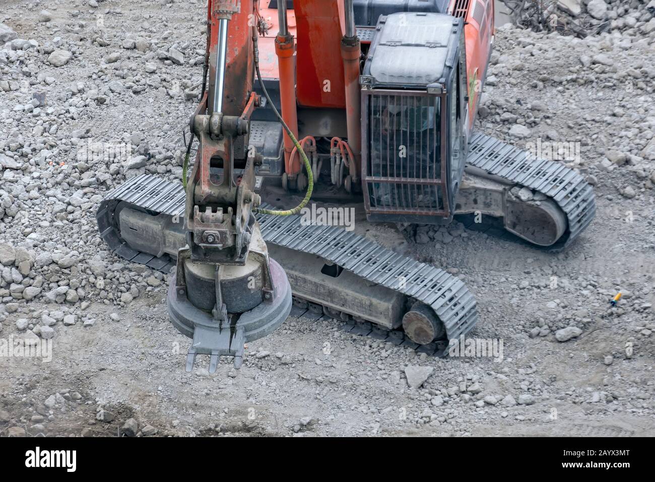 Gru magnetica che carica metalli di scarto sulle rovine di un cantiere Foto Stock